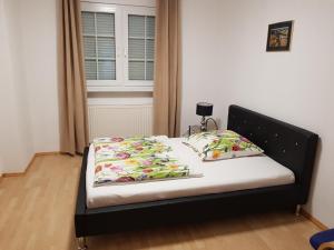 a bed with a black frame and two pillows at Zimmer in wundervoller Stadtvilla in Lehrte
