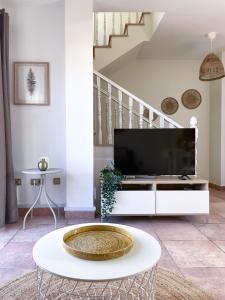 a living room with a tv and a table at Casa Dorada by Best Holidays Fuerteventura in Corralejo