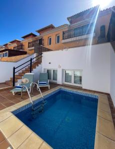 a swimming pool with two chairs and a water fountain at Casa Dorada by Best Holidays Fuerteventura in Corralejo