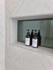 two bottles of soap sitting on a shelf in a bathroom at Bogside View Suite in Derry Londonderry +1 photo