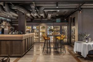 a restaurant with a bar with yellow stools at Biologen Herdla in Askøy