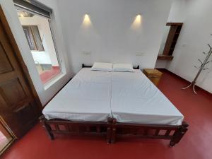 a large bed in a room with a window at Marari Irine Homestay in Mararikulam