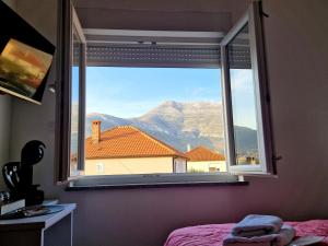 a bedroom window with a view of a mountain at Apartments Miš in Trebinje