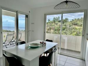 a dining room with a table and a view of the ocean at Appartement Mare è Machja vue mer in Sari Solenzara