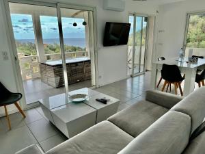 a living room with a couch and a table at Appartement Mare è Machja vue mer in Sari Solenzara