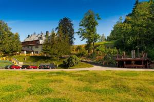 a house on a hill with cars parked in a field at Centrum Green Hill Business & SPA in Wisła