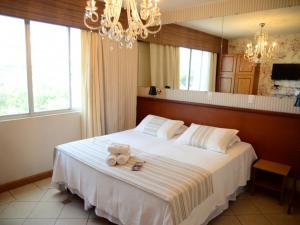 a bedroom with a bed with two teddy bears on it at Germanias Blumen Hotel in Passo Fundo +160 photos