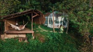 a woman standing in a hammock in front of a house at Bubble Siargao in General Luna