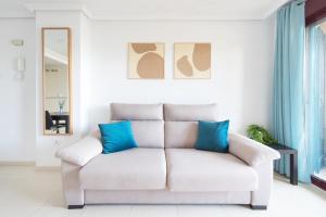 - un canapé blanc avec des oreillers bleus dans le salon dans l'établissement Blue Horizon, à Peñíscola 18 autres photos