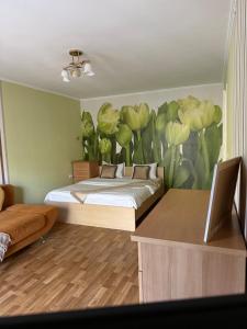 a bedroom with a bed with a flower mural on the wall at Gazelle 1 in Mykolaiv