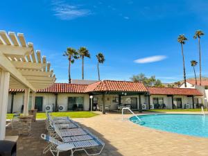 a resort with a swimming pool and palm trees at The Inn at Mission Lakes in Desert Hot Springs