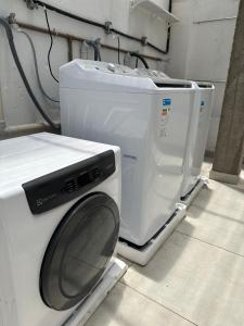 a washing machine and a dryer sitting on a cart at ABA Hotel in Belém