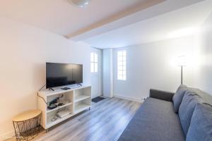 a living room with a couch and a flat screen tv at Appartement spacieux 2 Ch - 2 SDB - Proche Paris et Disneyland in Noisy-le-Grand