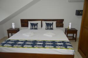 a bed with blue and white sheets and pillows at Chez Payet Airport Guesthouse in Pointe Larue