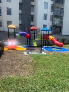 a playground with colorful slides and a bench in a park at Apartamento en Ricaurte Cundinamarca Bahia Solero Alicante in Ricaurte