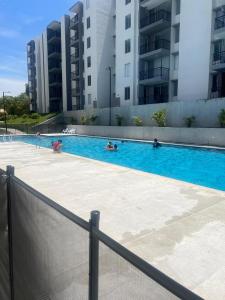 a large swimming pool with people in it with buildings at Apartamento en Ricaurte Cundinamarca Bahia Solero Alicante in Ricaurte