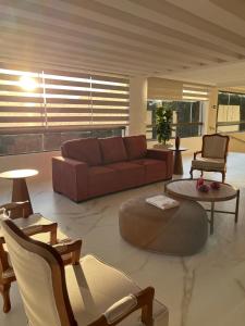 a living room with a brown couch and chairs at Ville Del Bosco Hotel in São Marcos