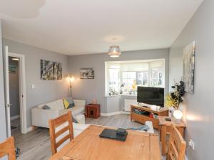 a living room with a couch and a table at Spindrift in Reighton