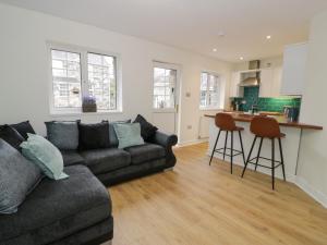 a living room with a couch and a kitchen at Bwythyn Yr Wyddfa in Caernarfon