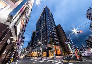 APA Hotel Higashi Shinjuku Kabukicho Tower في طوكيو: مبنى شاهق في وسط المدينة