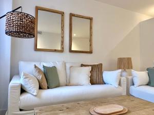 ein Wohnzimmer mit einem weißen Sofa und zwei Spiegeln in der Unterkunft Beach LUXURY - ALTEA Puerto de Campomanes in Altea