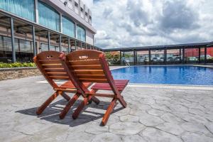 a wooden chair sitting next to a swimming pool at VIP Hotel Segamat in Segamat