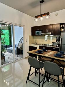 a kitchen and dining room with a table and chairs at Los Ausoles Home with Jacuzzi, HotSprings Ahuachapán in Ahuachapán