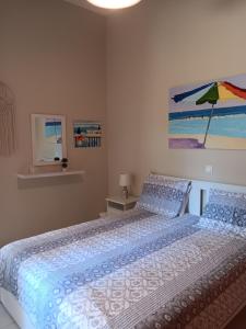 a bedroom with a bed with a blue comforter at Giulia's Beach House in Rhodes Town