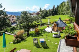 een balkon met uitzicht op een tuin met een huis bij Alps Residence in Nova Ponente