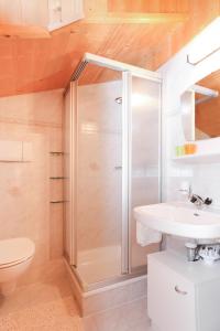 uma casa de banho com um chuveiro e um lavatório. em Alps Residence em Nova Ponente