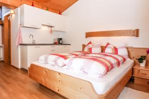 a bedroom with a wooden bed with red and white pillows at Alps Residence in Nova Ponente