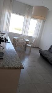 a living room with a table and chairs and a window at Résidence touristique les jasmins الياسمين in Les Sablettes Mazagran-Plage