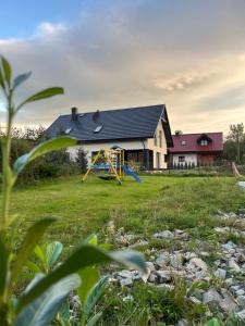a house with a playground in the yard at Domek nad Poniczanką in Rabka-Zdroj +16 photos