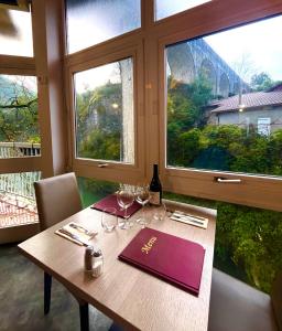 drewniany stół z kieliszkami do wina i oknem w obiekcie hotel restaurant le saint nazaire w mieście Saint-Nazaire-en-Royans