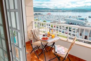 a table and chairs on a balcony with a view of a harbor at Combarro Port in Combarro