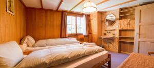 a bedroom with two beds and a sink and a window at Chalet Suveran 2 in Arosa