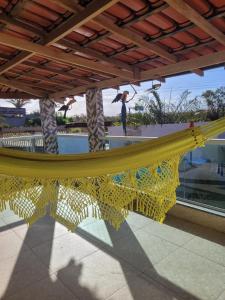 a hammock on a patio with people in the background at Casa Aconchegante in Anchieta