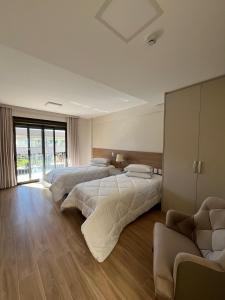 a bedroom with two beds and a couch at Ville Del Bosco Hotel in São Marcos +38 photos