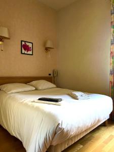 sypialnia z dużym łóżkiem z białymi prześcieradłami w obiekcie hotel restaurant le saint nazaire w mieście Saint-Nazaire-en-Royans