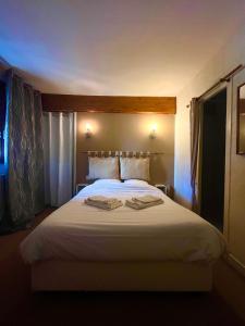 sypialnia z białym łóżkiem i 2 ręcznikami w obiekcie hotel restaurant le saint nazaire w mieście Saint-Nazaire-en-Royans