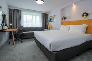a hotel room with a large bed and a desk at Holiday Inn Bristol Filton by IHG in Bristol