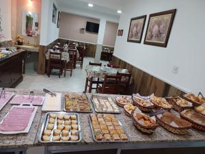 ein Buffet mit vielen verschiedenen Gebäcksorten auf einem Tisch in der Unterkunft Pousada Nossa Senhora das Graças in Cachoeira Paulista + 22 Fotos