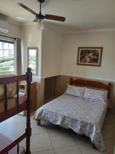 ein Schlafzimmer mit einem Bett und einem Deckenventilator in der Unterkunft Pousada Nossa Senhora das Graças in Cachoeira Paulista