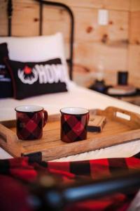 two coffee cups on a tray on a bed at The Green Acres Cabin in Hamilton
