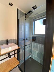 Un baño con lavabo y ducha de cristal. en Cabana charmosa com vista deslumbrante!, en Morungaba 22 fotos más