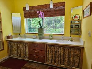 a bathroom with two sinks and a window at Ka'awa Loa Plantation in Captain Cook +19 photos
