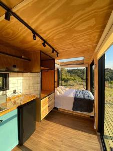 una cocina con una cama en el medio de una casa en Cabana charmosa com vista deslumbrante!, en Morungaba