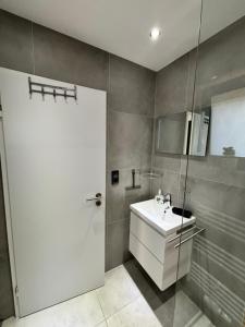 a bathroom with a white sink and a shower at Ferienwohnung LeJaju in Friedrichsthal +20 photos