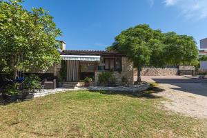a house with a patio and a yard at Vila Murvica in Pag