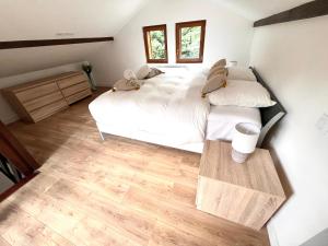 a bedroom with two beds and a wooden floor at chalet cosy - Vallée Verte in Fillinges